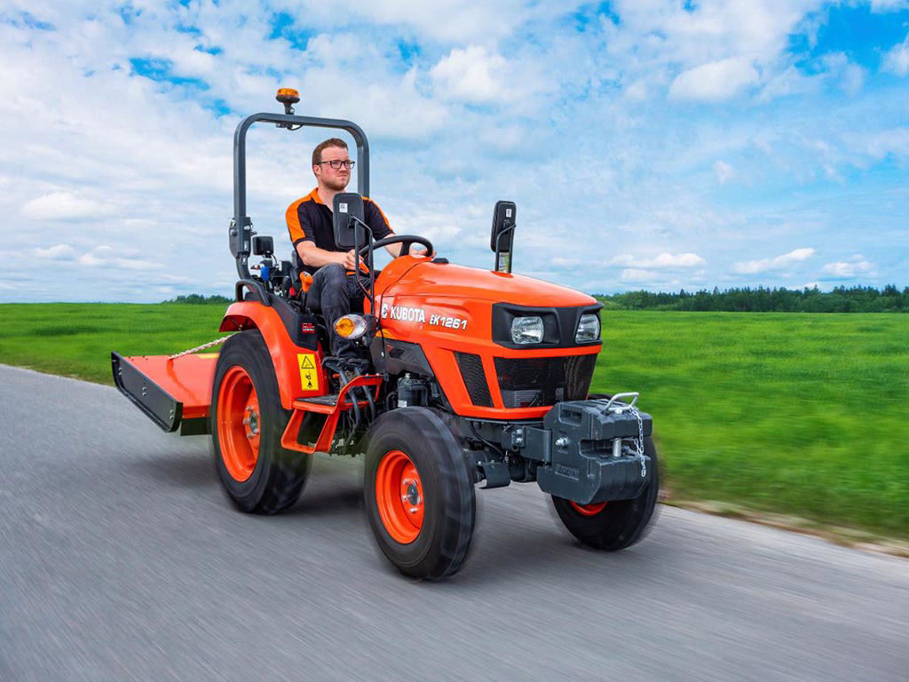 Man driving Kubota EK1-261 Compact Tractor in the Countryside